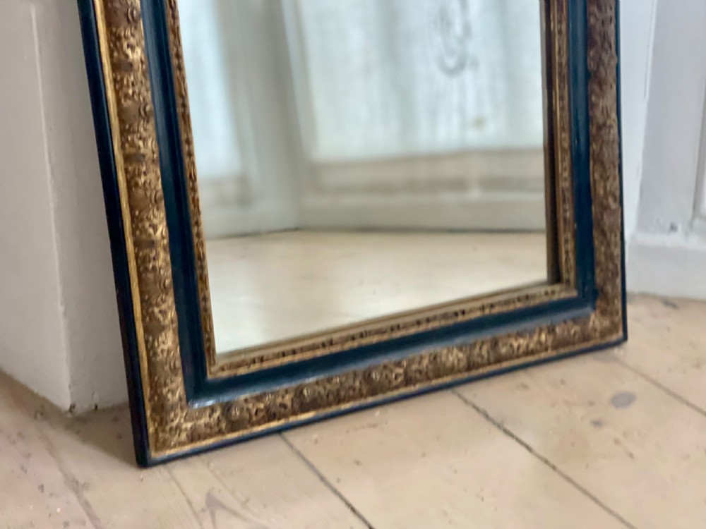 An arched antique French mirror featuring a dark painted outer border and a giltwood frame carved with foliate patterns. View II