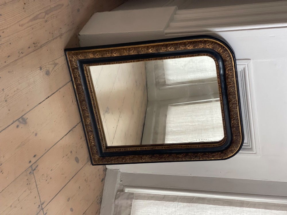 An arched antique French mirror featuring a dark painted outer border and a giltwood frame carved with foliate patterns. View VIII