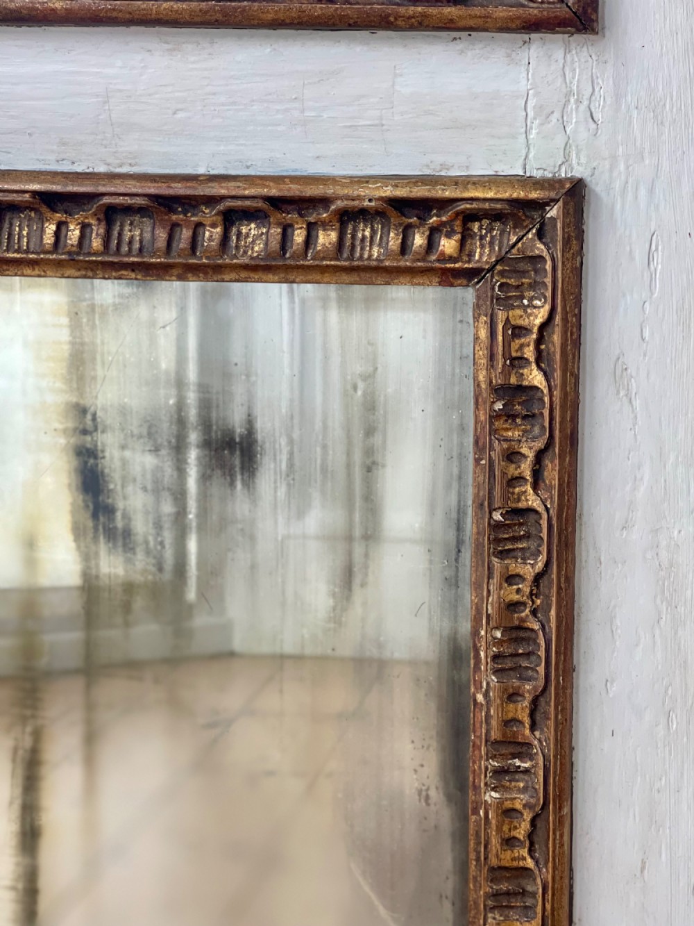 A tall rectangular antique French trumeau mirror featuring two glass panels within a painted cream frame with gilded carved mouldings and a shell crest. View III