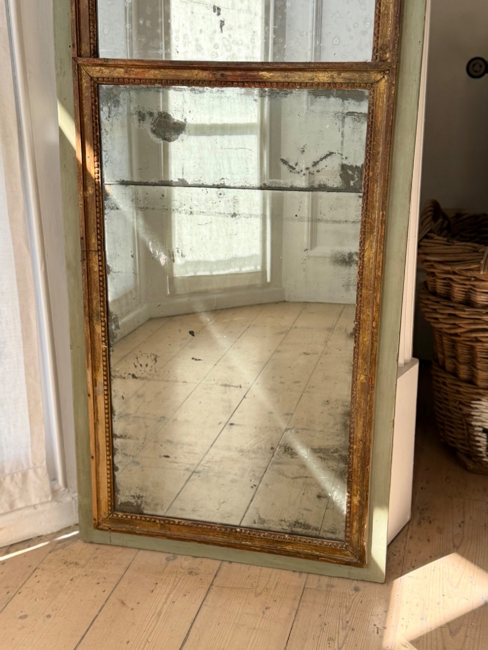 A tall rectangular French trumeau mirror featuring a sage green painted outer timber frame, a beaded gilt inner border, and two distressed mercury glass plates. View IV