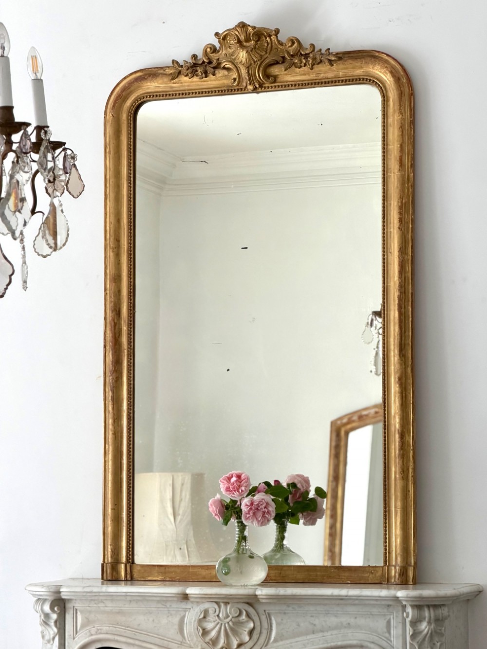 An antique French Louis Philippe wall mirror featuring a gilt frame with rounded upper corners, beaded inner border, and a carved crest. View II