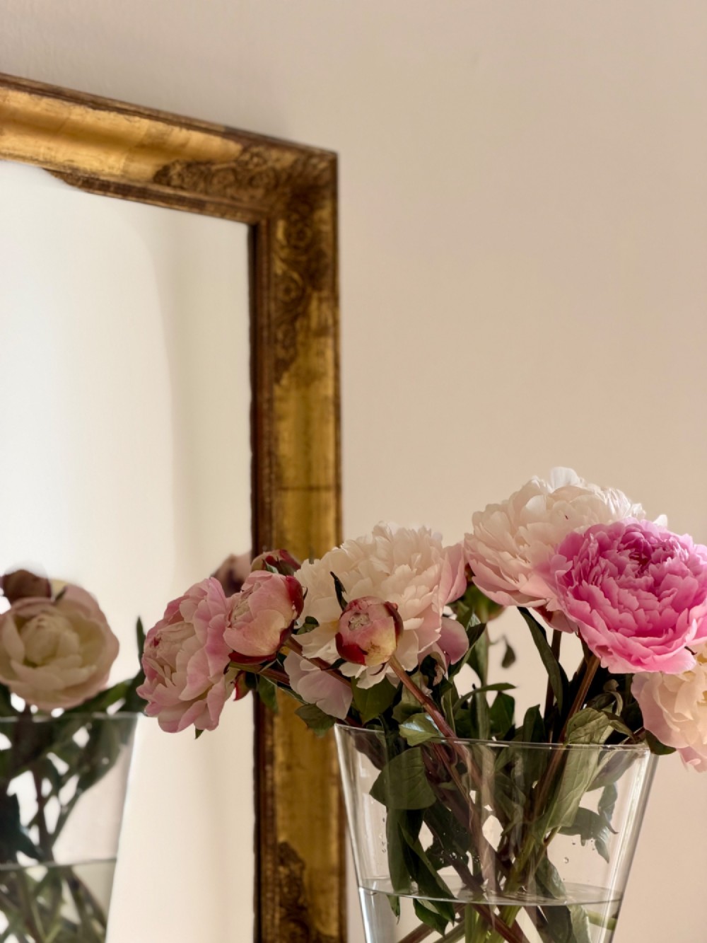 A rectangular antique French mirror framed in gold giltwood with ornate carved corner spandrels and subtle beaded borders. View X