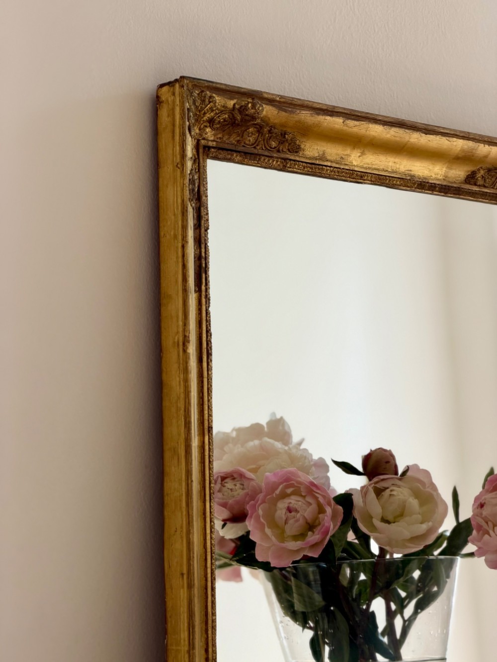 A rectangular antique French mirror framed in gold giltwood with ornate carved corner spandrels and subtle beaded borders. View XI