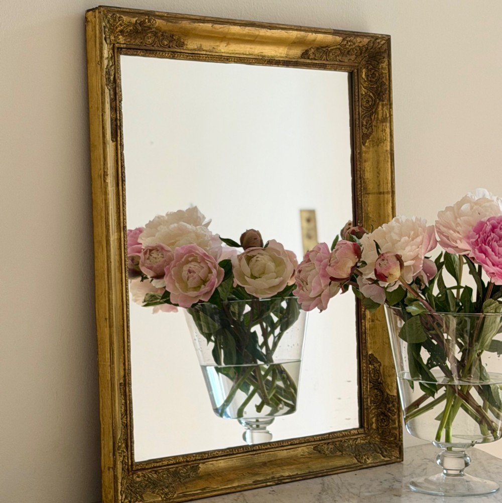 A rectangular antique French mirror framed in gold giltwood with ornate carved corner spandrels and subtle beaded borders. View XII