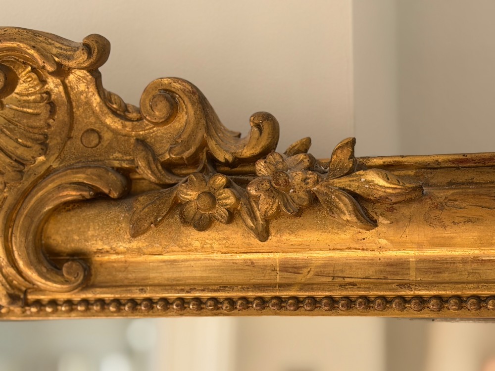 An antique French Louis Philippe wall mirror featuring a gilt frame with rounded upper corners, beaded inner border, and a carved crest. View IV