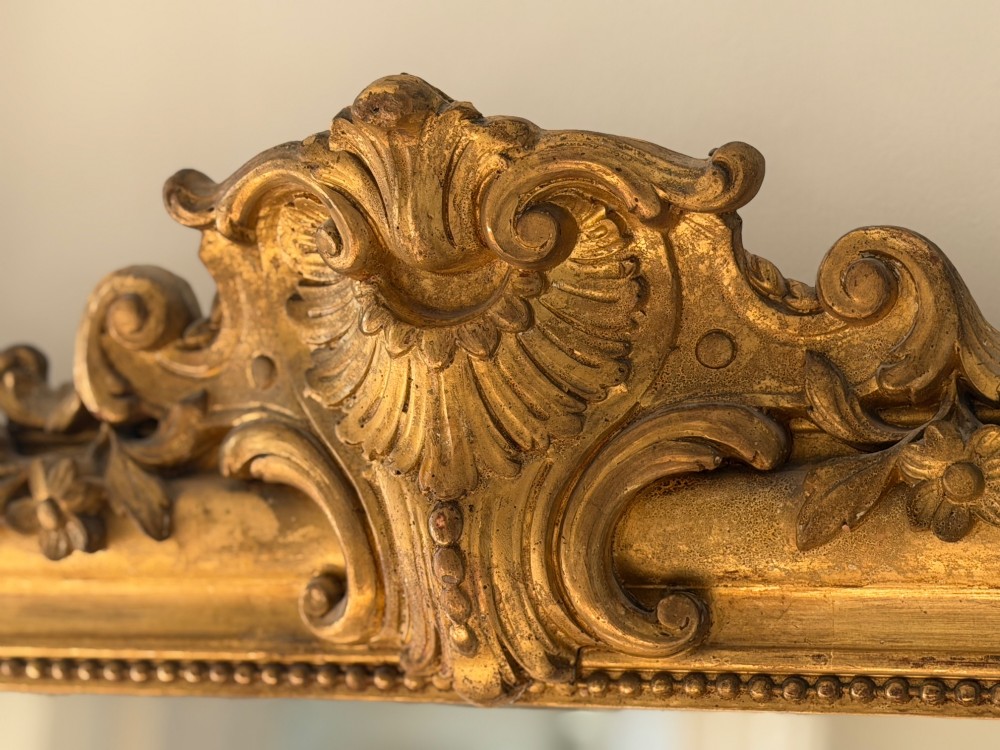 An antique French Louis Philippe wall mirror featuring a gilt frame with rounded upper corners, beaded inner border, and a carved crest. View V