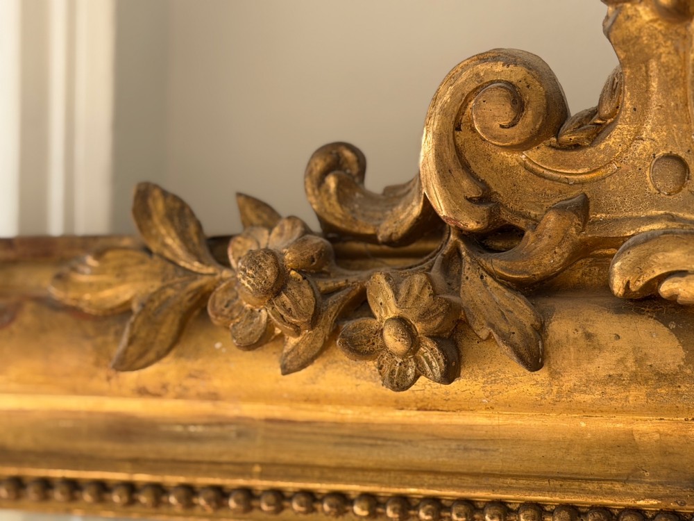 An antique French Louis Philippe wall mirror featuring a gilt frame with rounded upper corners, beaded inner border, and a carved crest. View VI