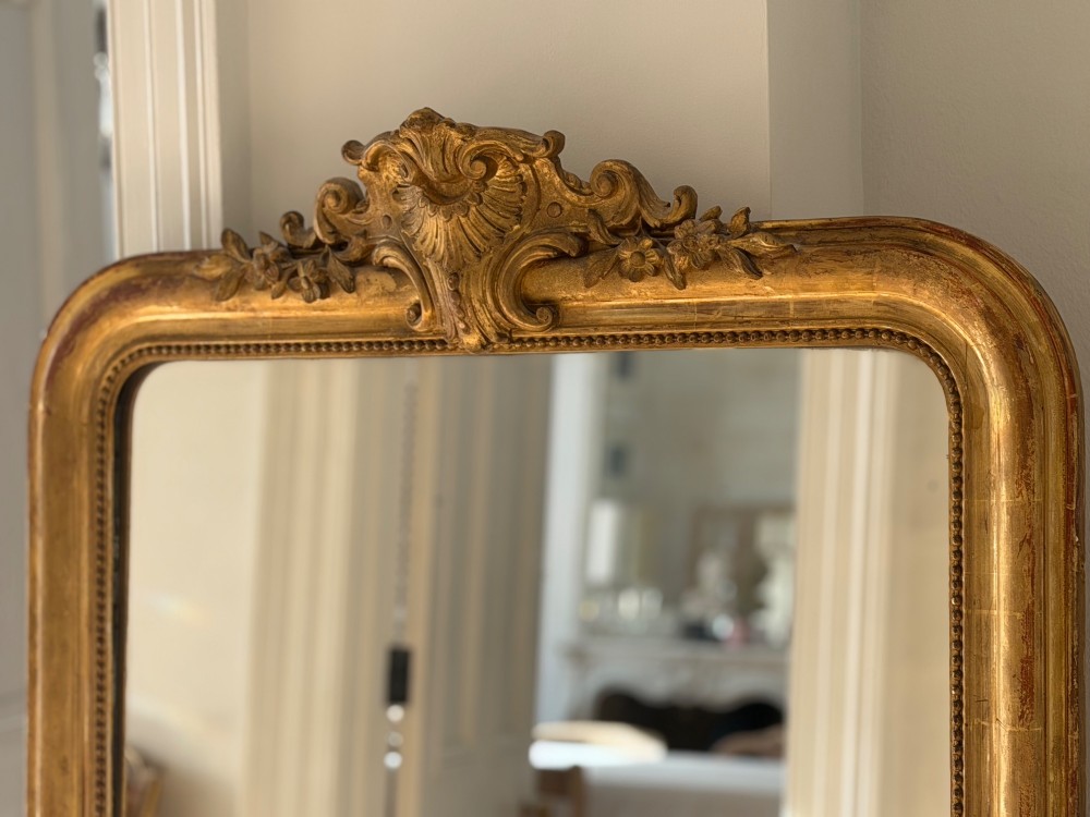An antique French Louis Philippe wall mirror featuring a gilt frame with rounded upper corners, beaded inner border, and a carved crest. View IX