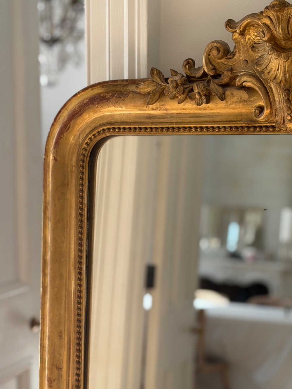 An antique French Louis Philippe wall mirror featuring a gilt frame with rounded upper corners, beaded inner border, and a carved crest. View X