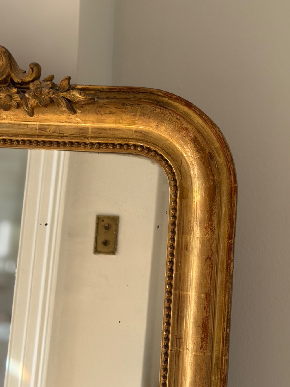 An antique French Louis Philippe wall mirror featuring a gilt frame with rounded upper corners, beaded inner border, and a carved crest. View XI