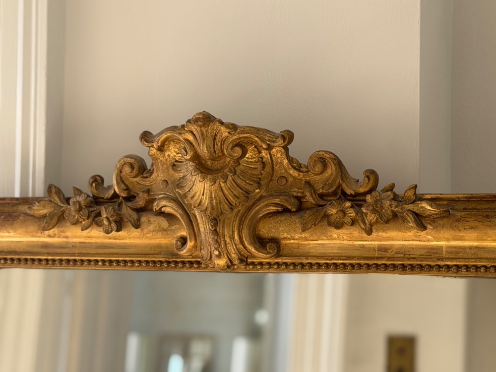 An antique French Louis Philippe wall mirror featuring a gilt frame with rounded upper corners, beaded inner border, and a carved crest. View XII