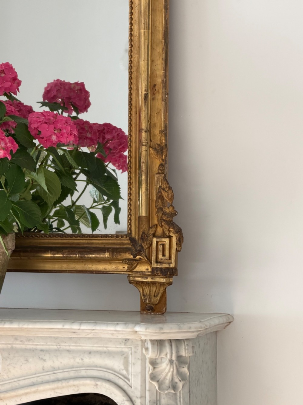 A tall antique French giltwood overmantel mirror featuring an arched frame topped with an ornate carved crest. View X