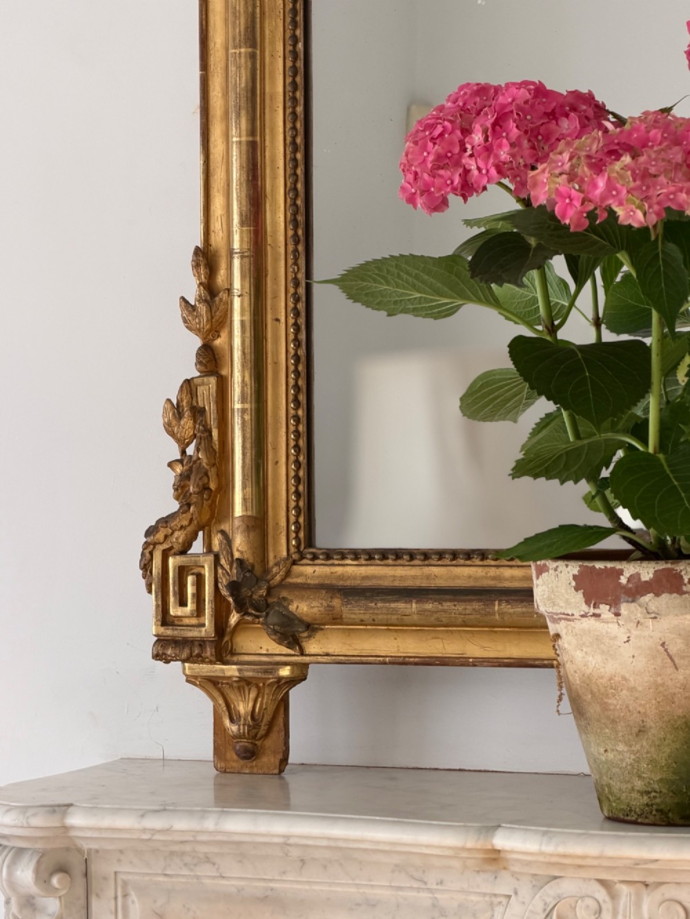 A tall antique French giltwood overmantel mirror featuring an arched frame topped with an ornate carved crest. View XIII