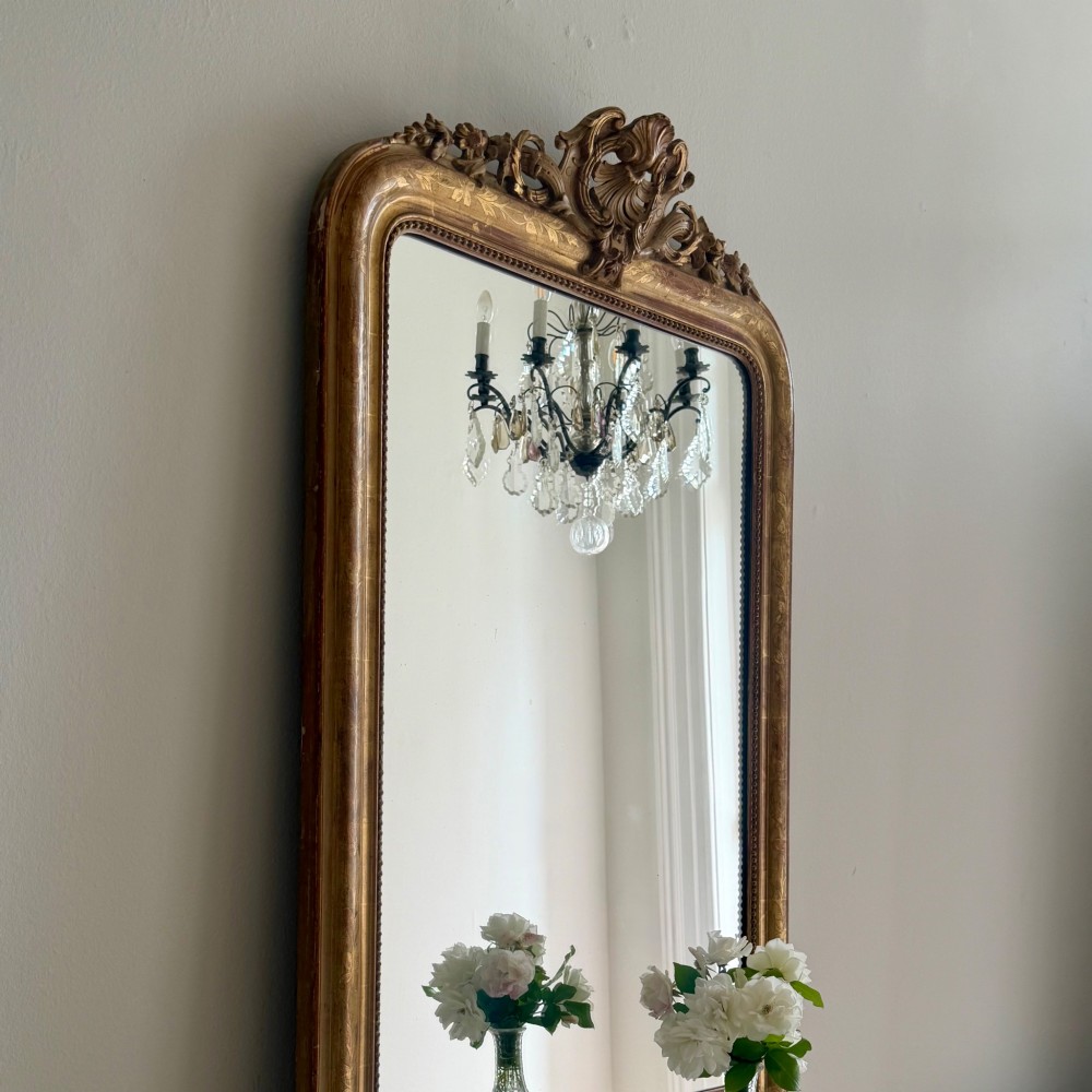 An antique French Louis Philippe giltwood mirror featuring a carved crest and incised floral frame detailing. View VII