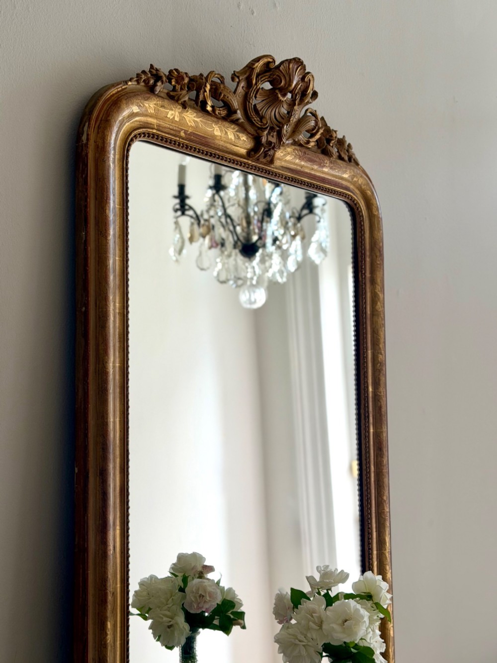 An antique French Louis Philippe giltwood mirror featuring a carved crest and incised floral frame detailing. View X