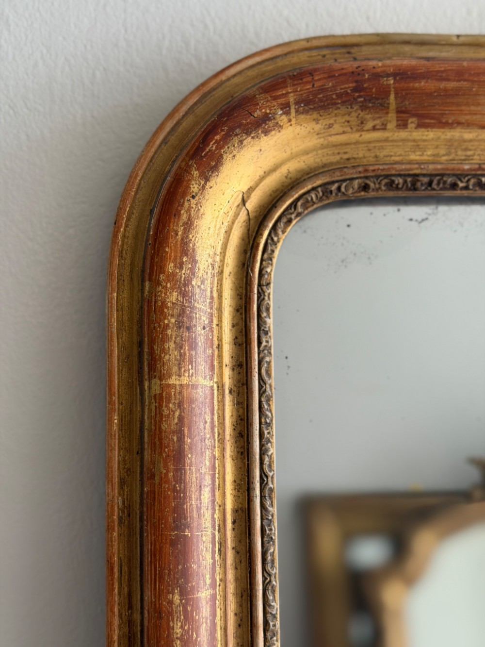 An antique French Louis Philippe wall mirror with a gold leaf gilded wooden frame featuring rounded upper corners and a beaded inner edge. View III