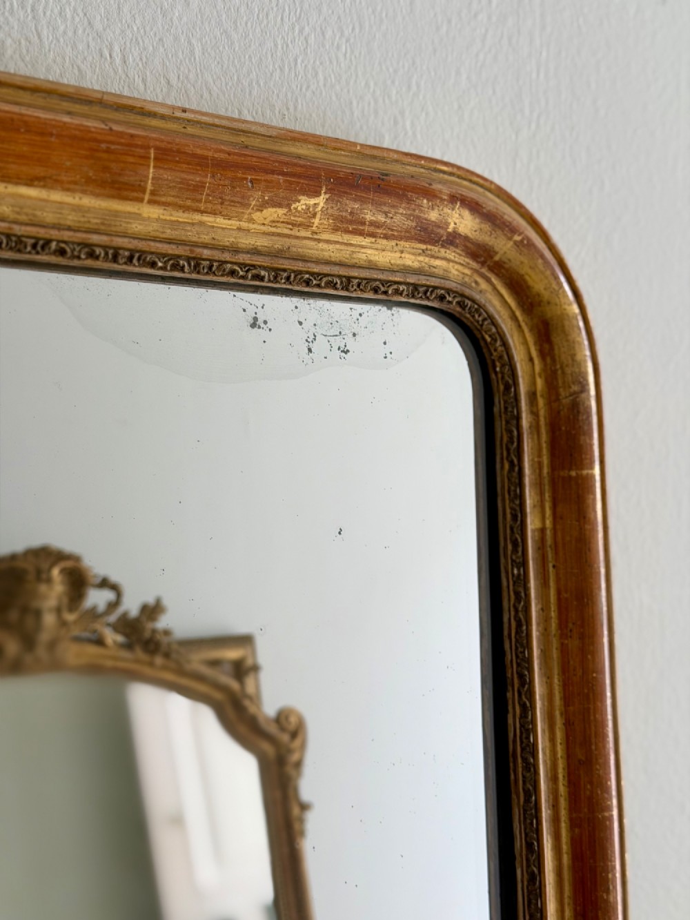 An antique French Louis Philippe wall mirror with a gold leaf gilded wooden frame featuring rounded upper corners and a beaded inner edge. View IV