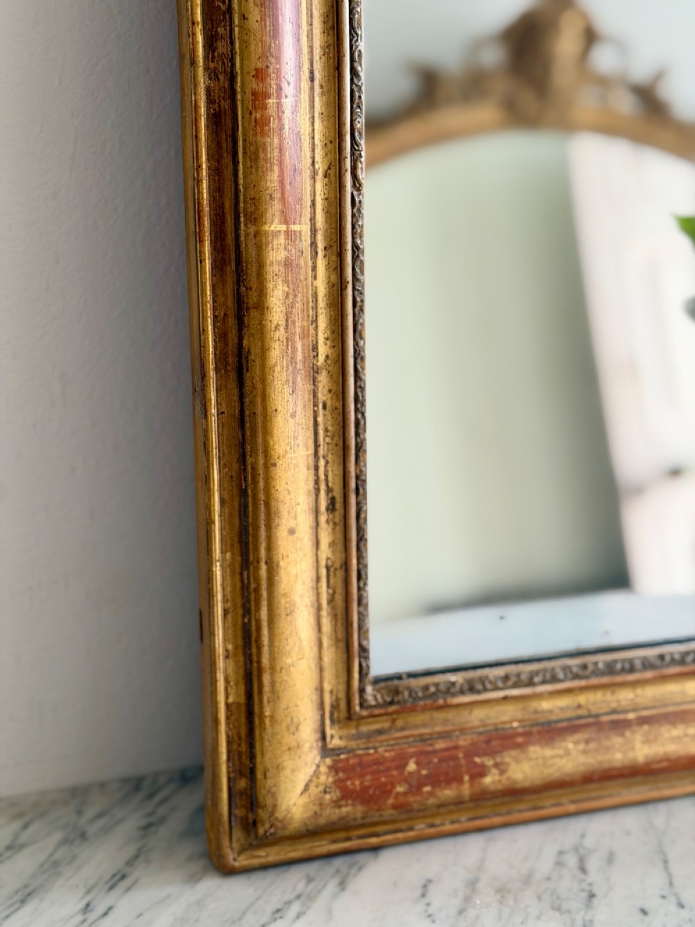 An antique French Louis Philippe wall mirror with a gold leaf gilded wooden frame featuring rounded upper corners and a beaded inner edge. View V