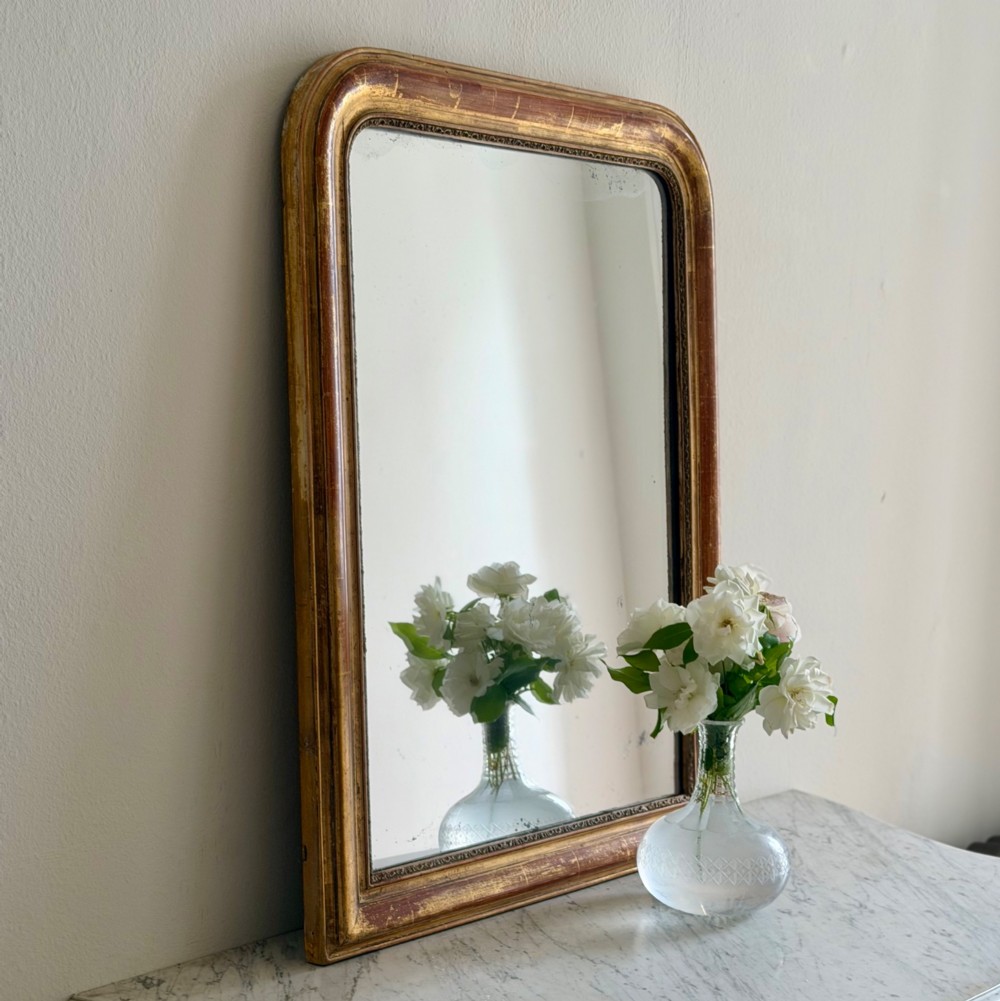 An antique French Louis Philippe wall mirror with a gold leaf gilded wooden frame featuring rounded upper corners and a beaded inner edge. View VI