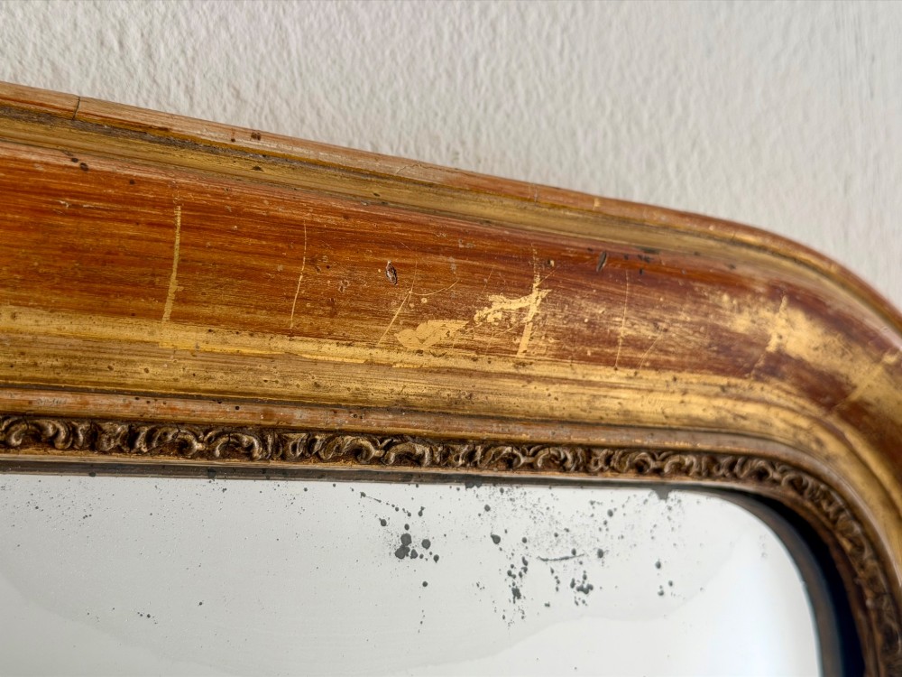 An antique French Louis Philippe wall mirror with a gold leaf gilded wooden frame featuring rounded upper corners and a beaded inner edge. View VII