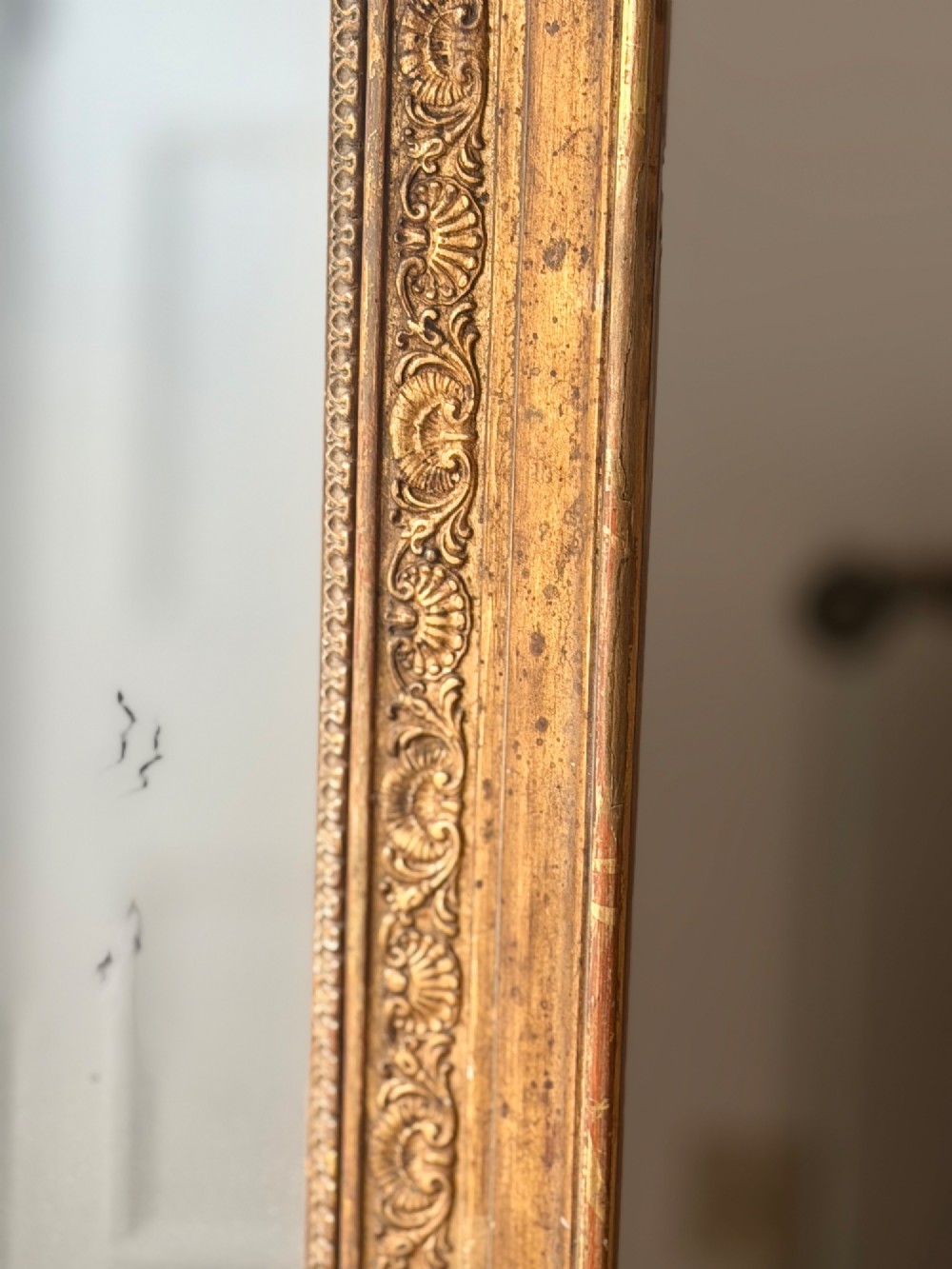 A tall 18th-century French rectangular mirror featuring a carved gold leaf frame and a two-part split mercury glass plate. View II