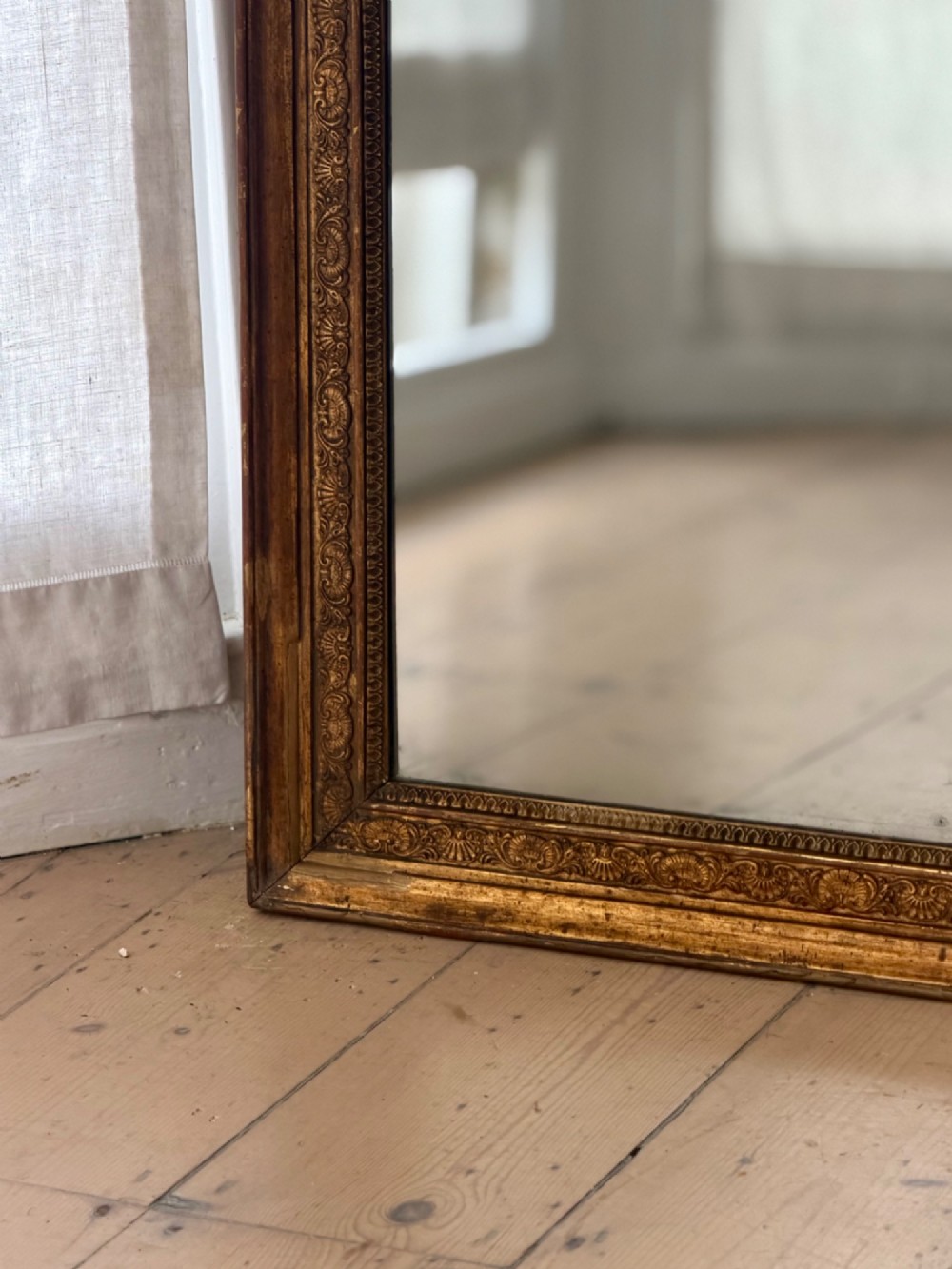 A tall 18th-century French rectangular mirror featuring a carved gold leaf frame and a two-part split mercury glass plate. View V