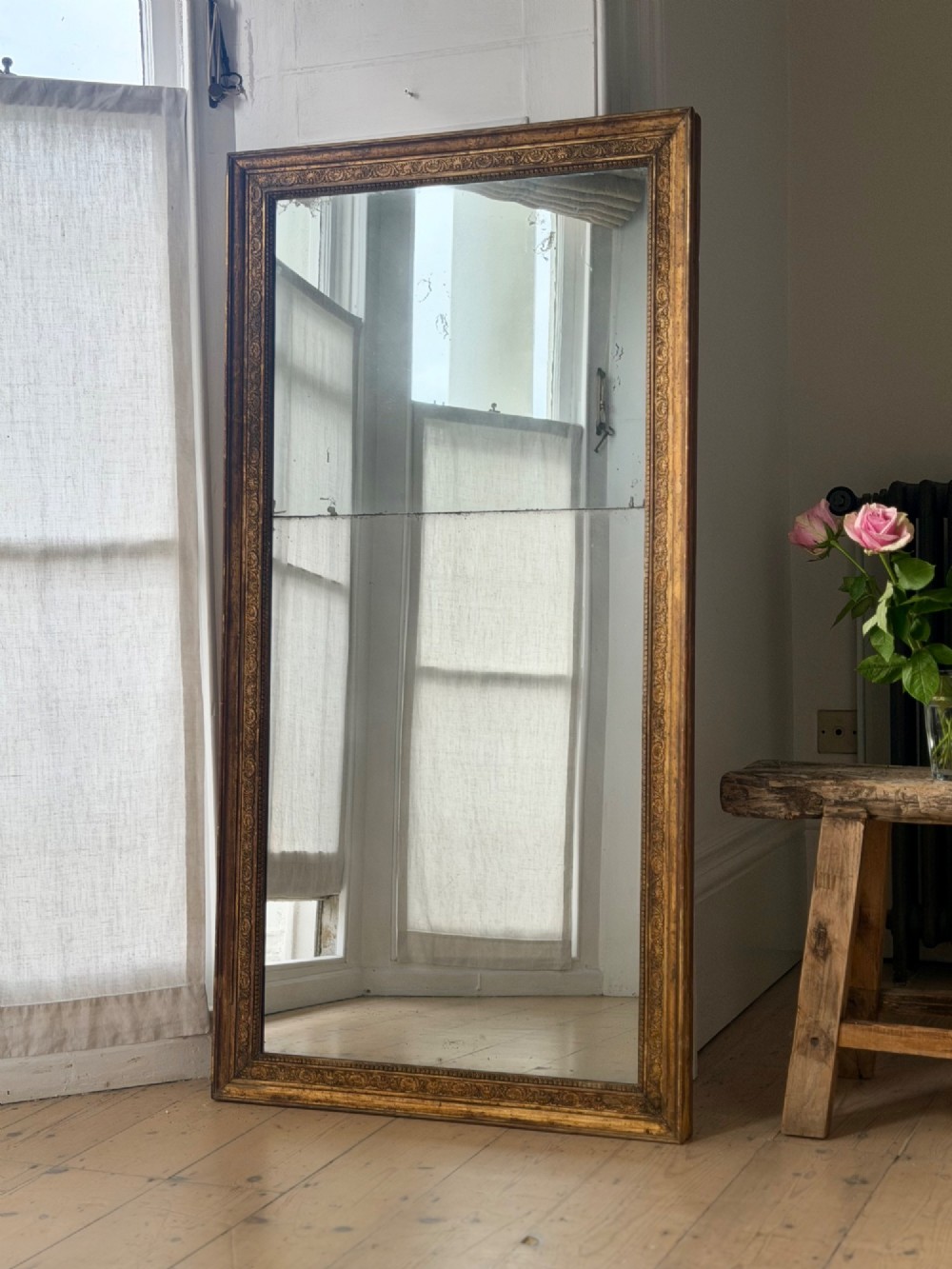 A tall 18th-century French rectangular mirror featuring a carved gold leaf frame and a two-part split mercury glass plate. View IX