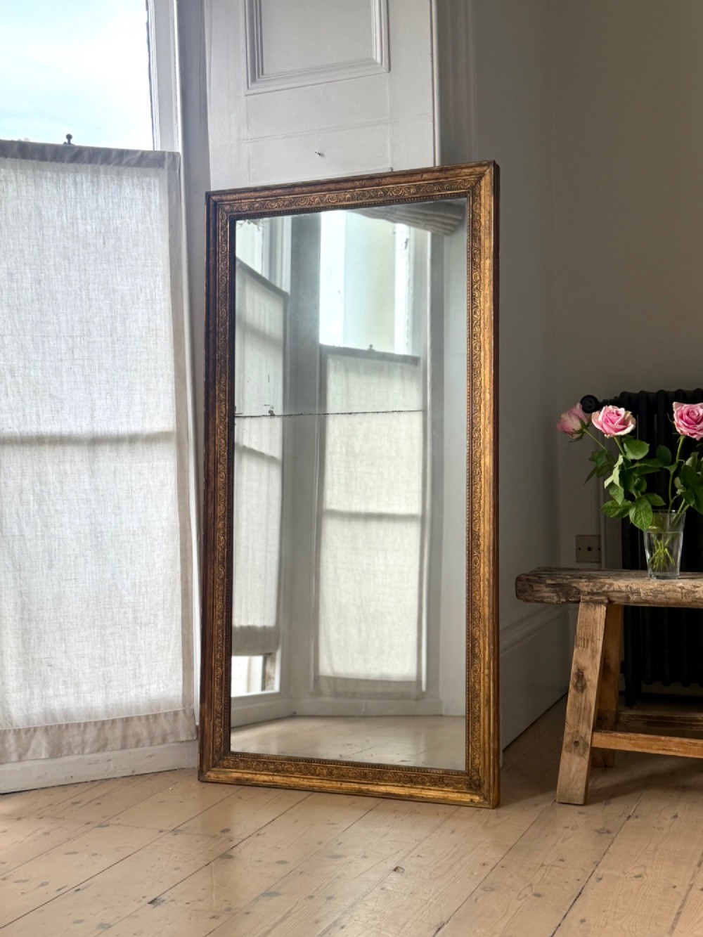 A tall 18th-century French rectangular mirror featuring a carved gold leaf frame and a two-part split mercury glass plate. View X