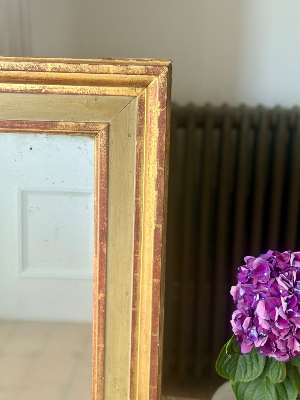 A large rectangular antique French mirror with a gold leaf and sage green painted wooden frame housing an original mercury glass plate. View VI