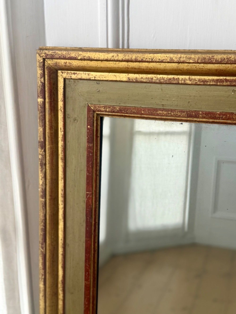 A large rectangular antique French mirror with a gold leaf and sage green painted wooden frame housing an original mercury glass plate. View VII