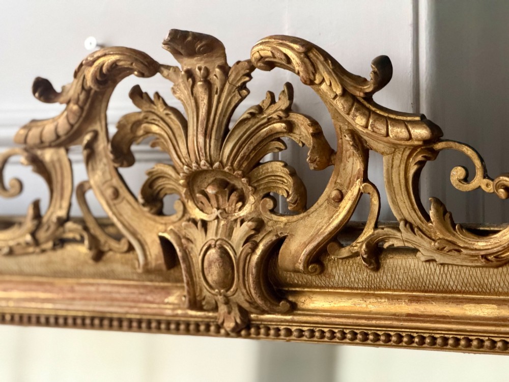 A tall French Louis Philippe mirror featuring a gold leaf frame with rounded upper shoulders, pearl bead moulding, and a decorative carved crest. View XI