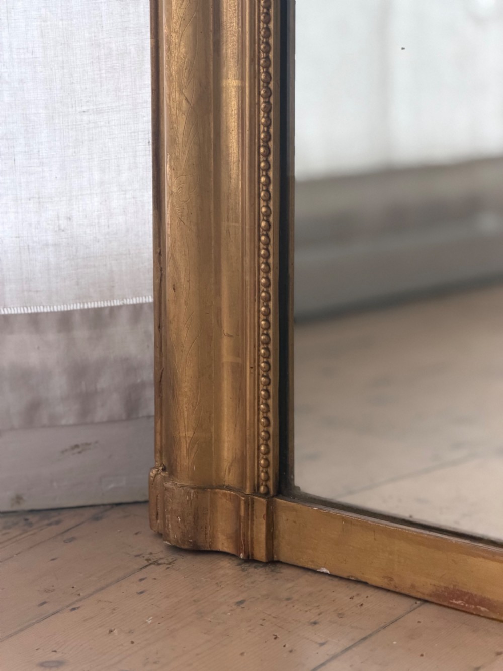 A large rectangular French Louis Philippe mirror featuring rounded top corners, a gilded frame with beaded inner moulding, and visible foxing on the glass plate. View VI