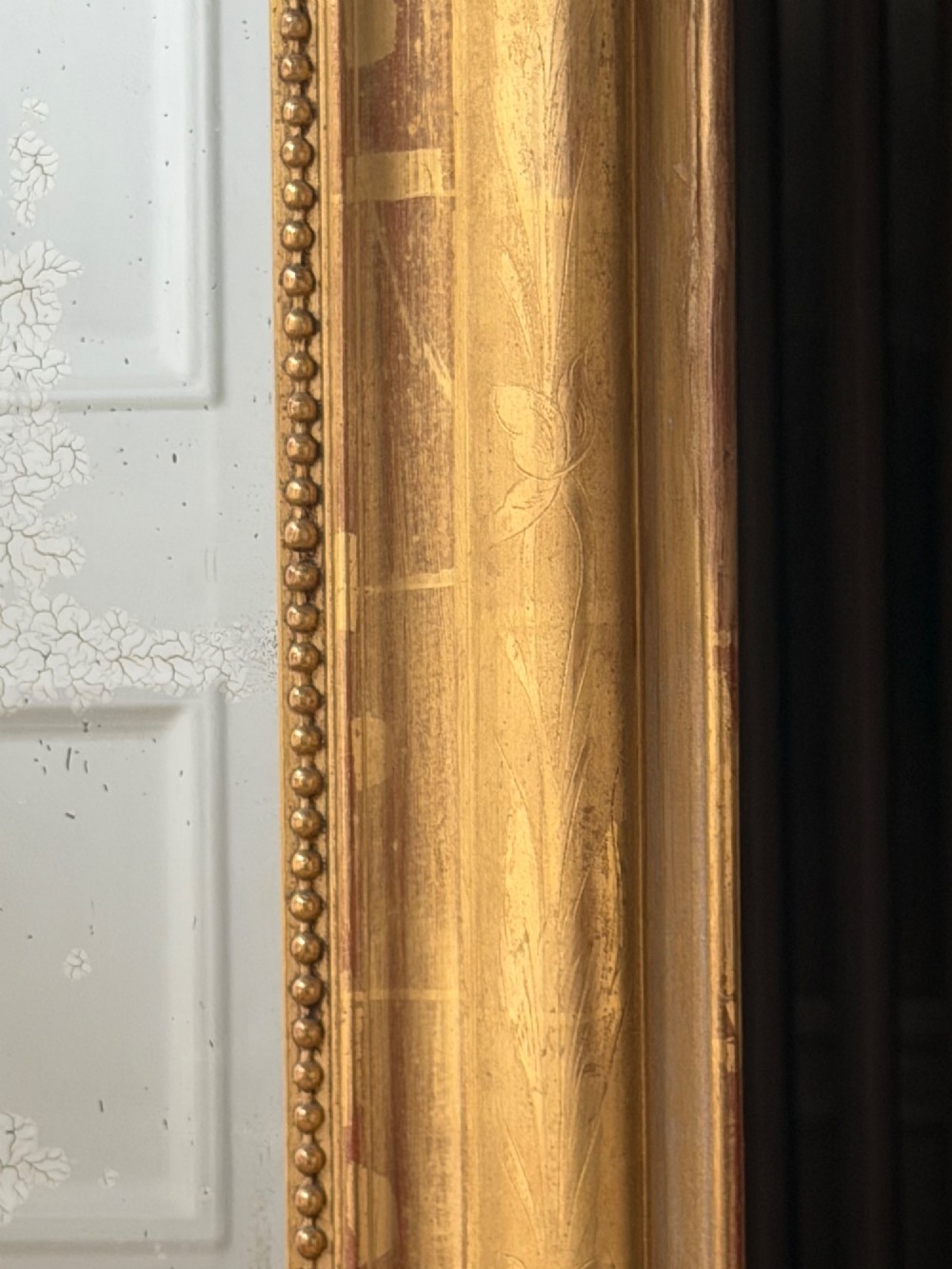 A large rectangular French Louis Philippe mirror featuring rounded top corners, a gilded frame with beaded inner moulding, and visible foxing on the glass plate. View IX