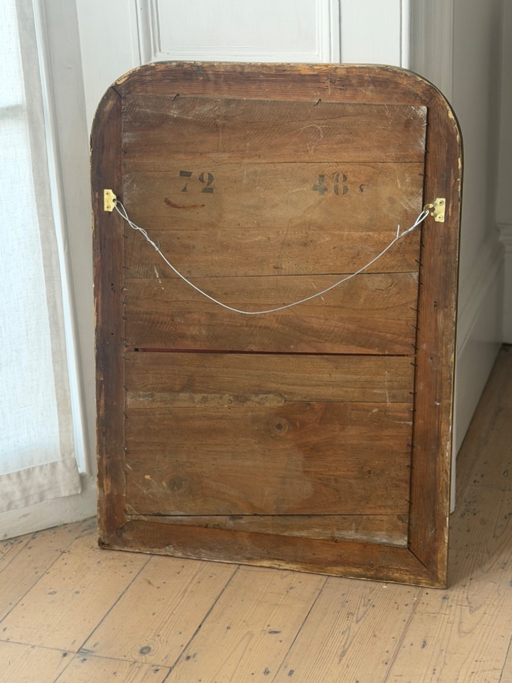 An antique Louis Philippe mirror with rounded upper corners, an incised crosshatch motif on the gilded frame, exposed white gesso, and a beaded inner border. View IV