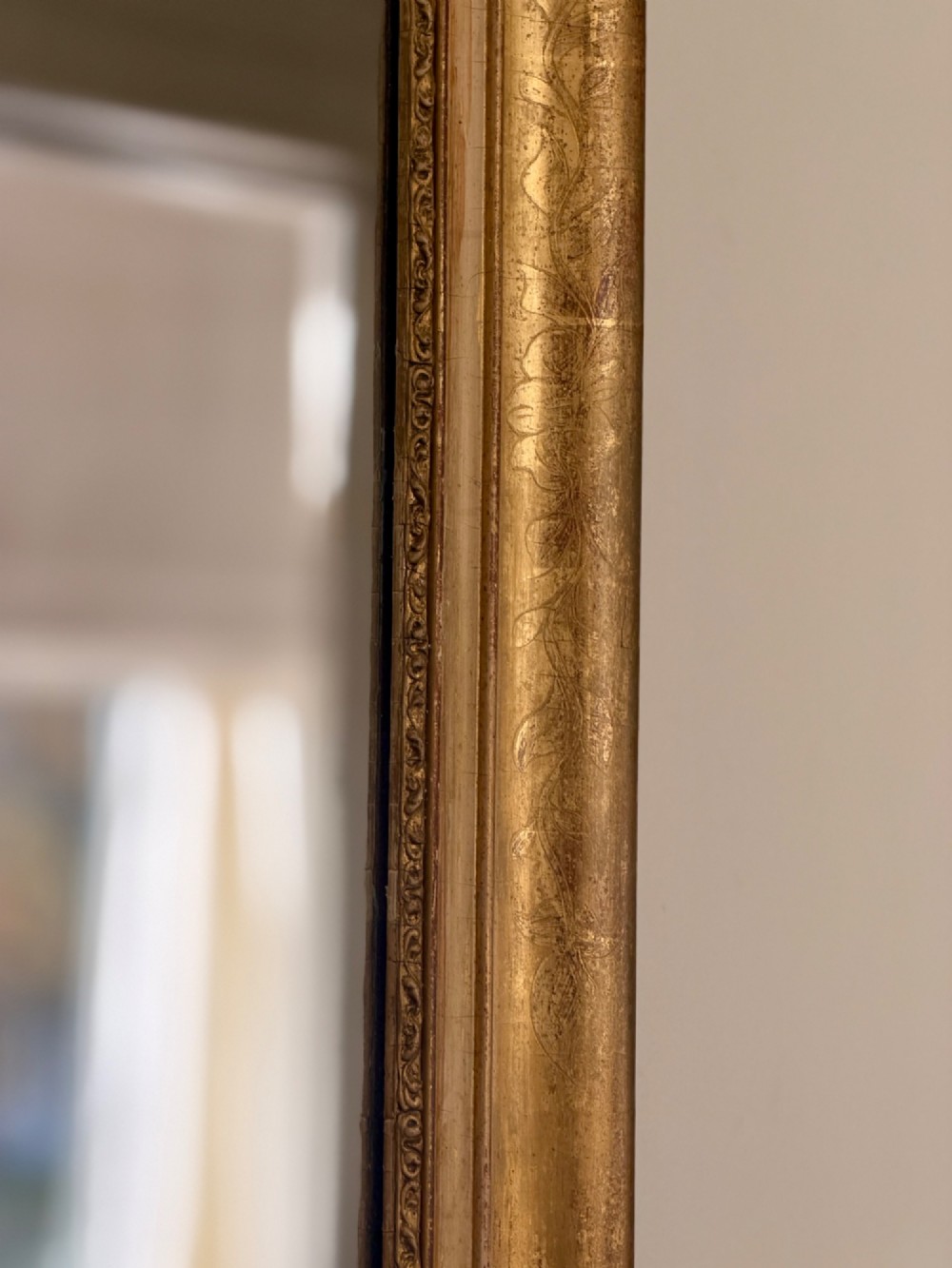 A tall rectangular nineteenth-century French Napoleon III mirror with a gilded and bare gesso frame featuring floral corner mouldings and a mercury glass plate. View VII