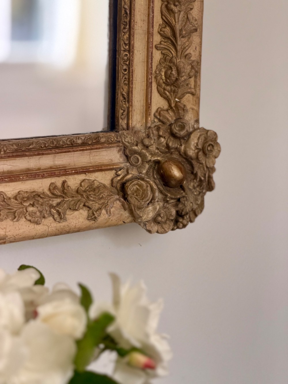 A tall rectangular nineteenth-century French Napoleon III mirror with a gilded and bare gesso frame featuring floral corner mouldings and a mercury glass plate. View X
