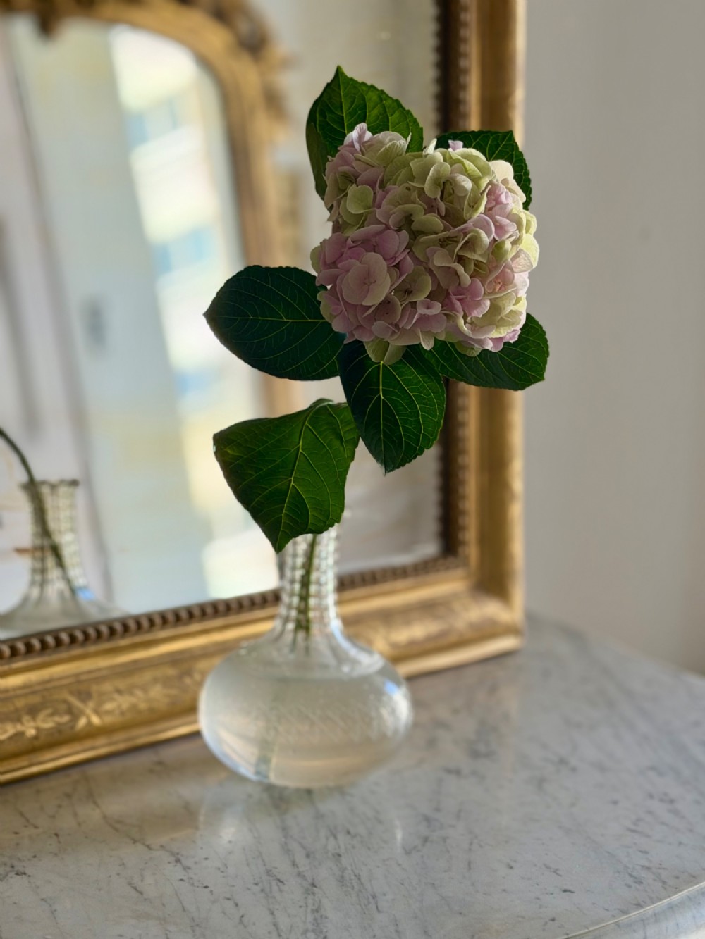 A rectangular 19th-century Louis Philippe mirror featuring rounded upper corners, an engraved gold leaf frame, beaded interior trim, and aged mirror glass. View V