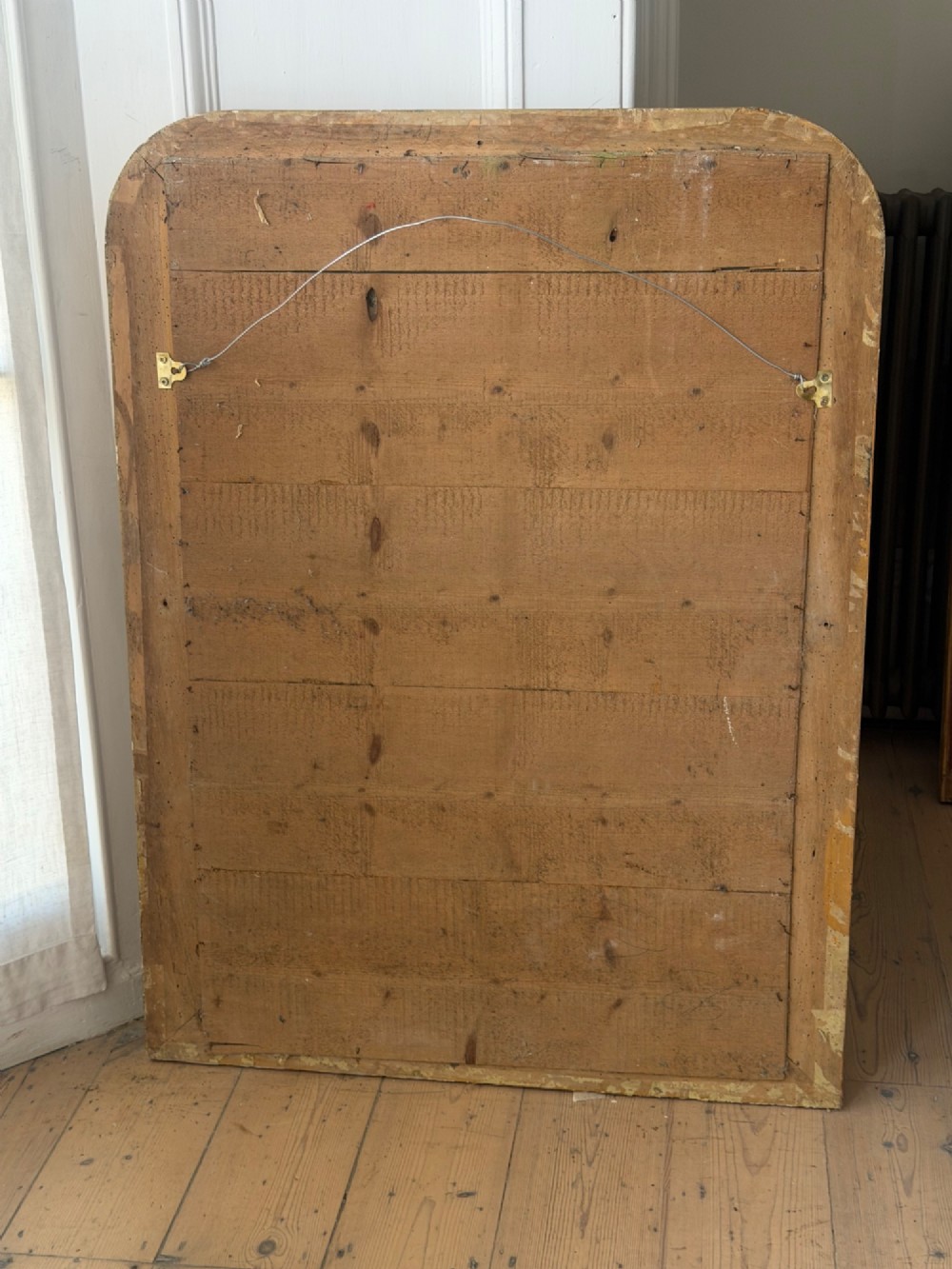A rectangular 19th-century Louis Philippe mirror featuring rounded upper corners, an engraved gold leaf frame, beaded interior trim, and aged mirror glass. View XI