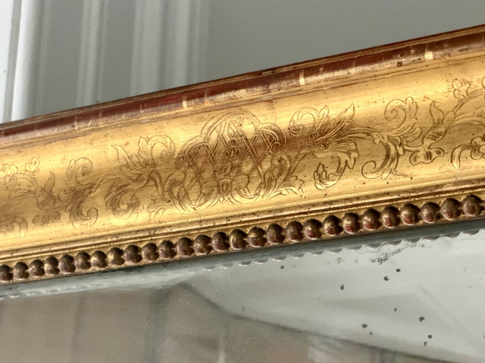 A large rectangular French Napoleon III giltwood leaner mirror featuring ornate carved foliate mouldings and an aged glass plate. View III