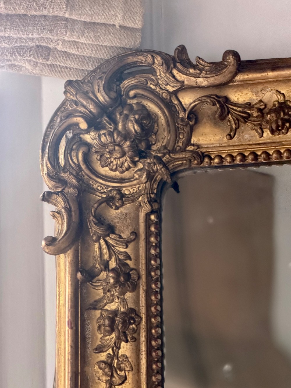 A large rectangular French Napoleon III giltwood leaner mirror featuring ornate carved foliate mouldings and an aged glass plate. View VI