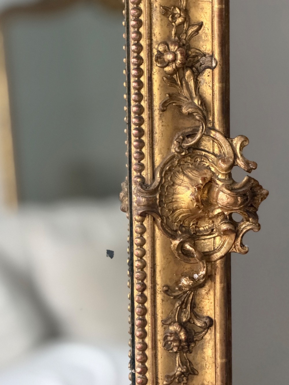A large rectangular French Napoleon III giltwood leaner mirror featuring ornate carved foliate mouldings and an aged glass plate. View VIII