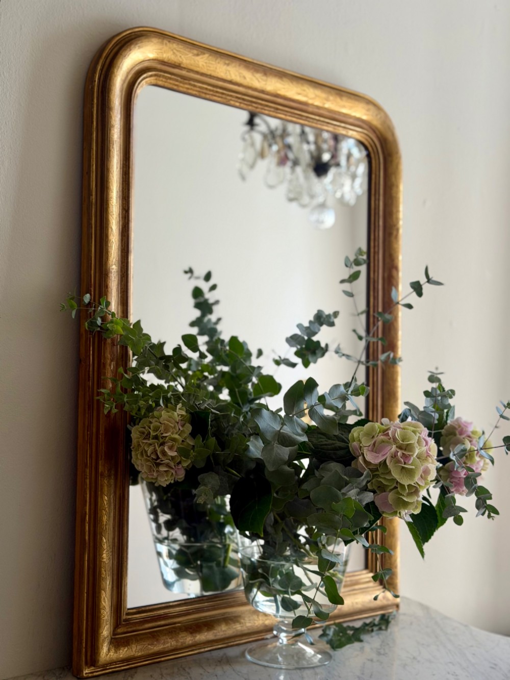 An antique French Louis Philippe wall mirror featuring a rectangular gilded frame with rounded upper corners, subtle etched foliate patterns, and a mercury glass plate. View V