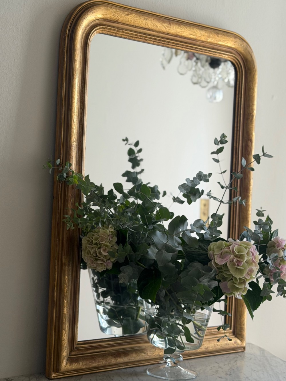 An antique French Louis Philippe wall mirror featuring a rectangular gilded frame with rounded upper corners, subtle etched foliate patterns, and a mercury glass plate. View X