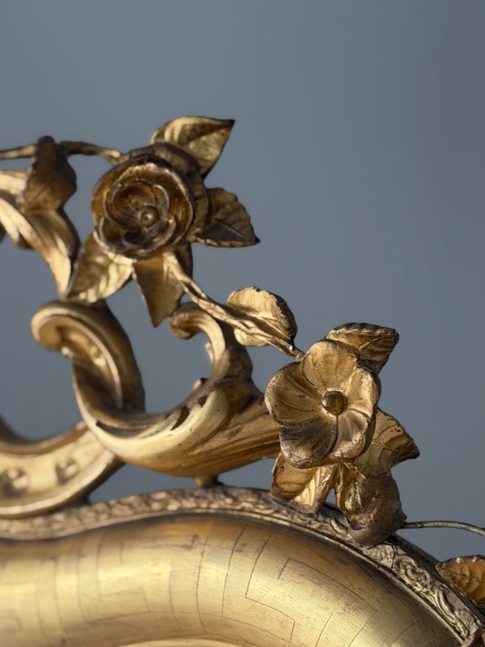 A large French Louis XV style giltwood mirror featuring an ornate rocaille cresting, foliate scrolls, and mercury glass mirror plate. View XI