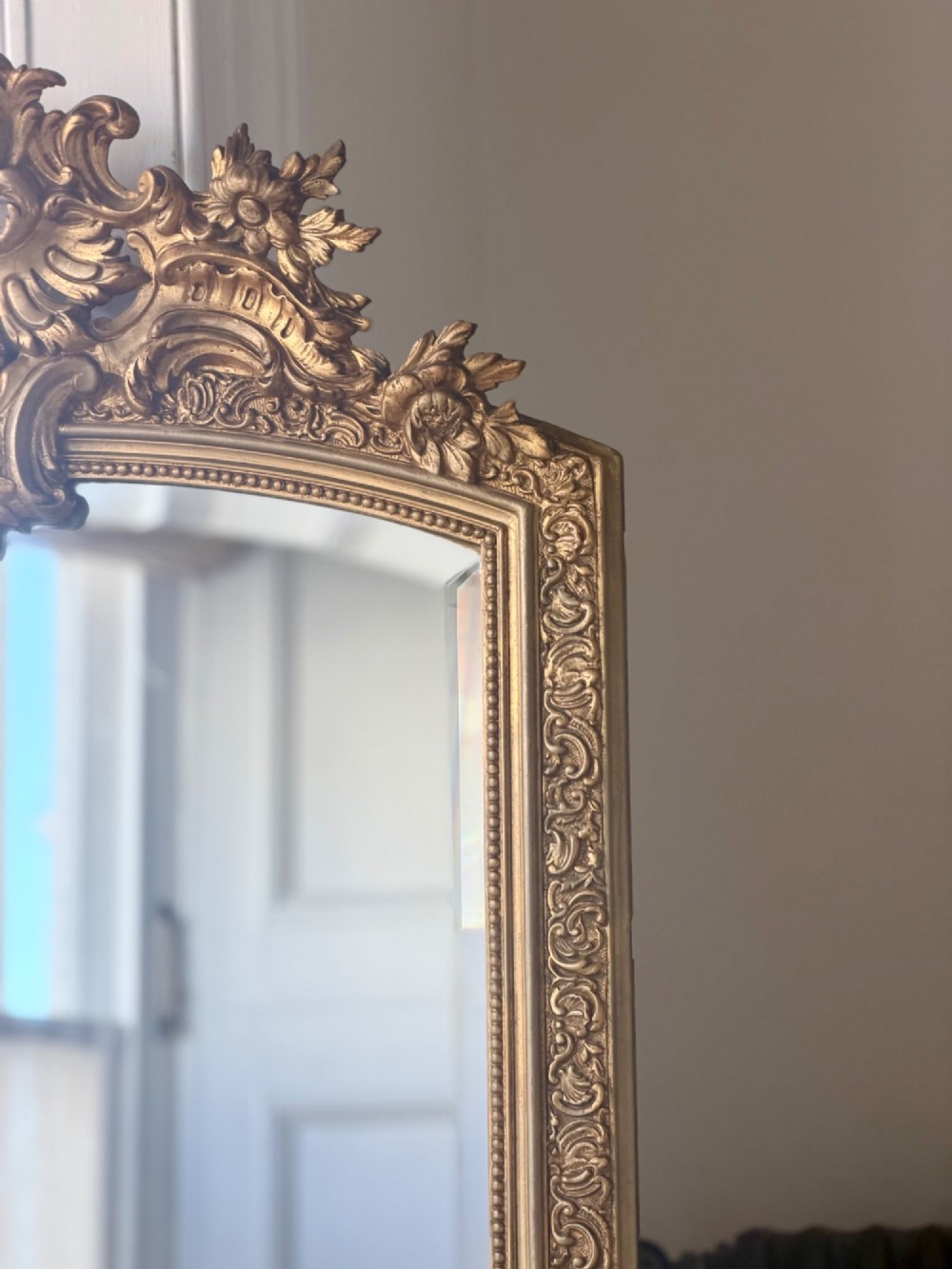 A large French gilded wood frame mirror featuring an arched top, a carved scroll cresting, and bevelled edge glass. View IV