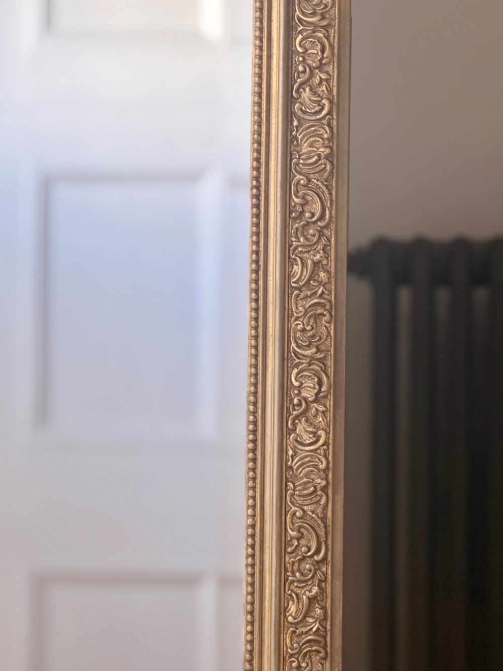 A large French gilded wood frame mirror featuring an arched top, a carved scroll cresting, and bevelled edge glass. View V