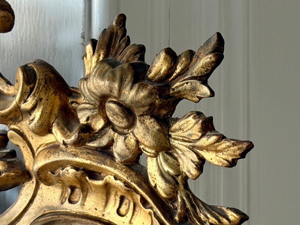 A large French gilded wood frame mirror featuring an arched top, a carved scroll cresting, and bevelled edge glass. View VIII
