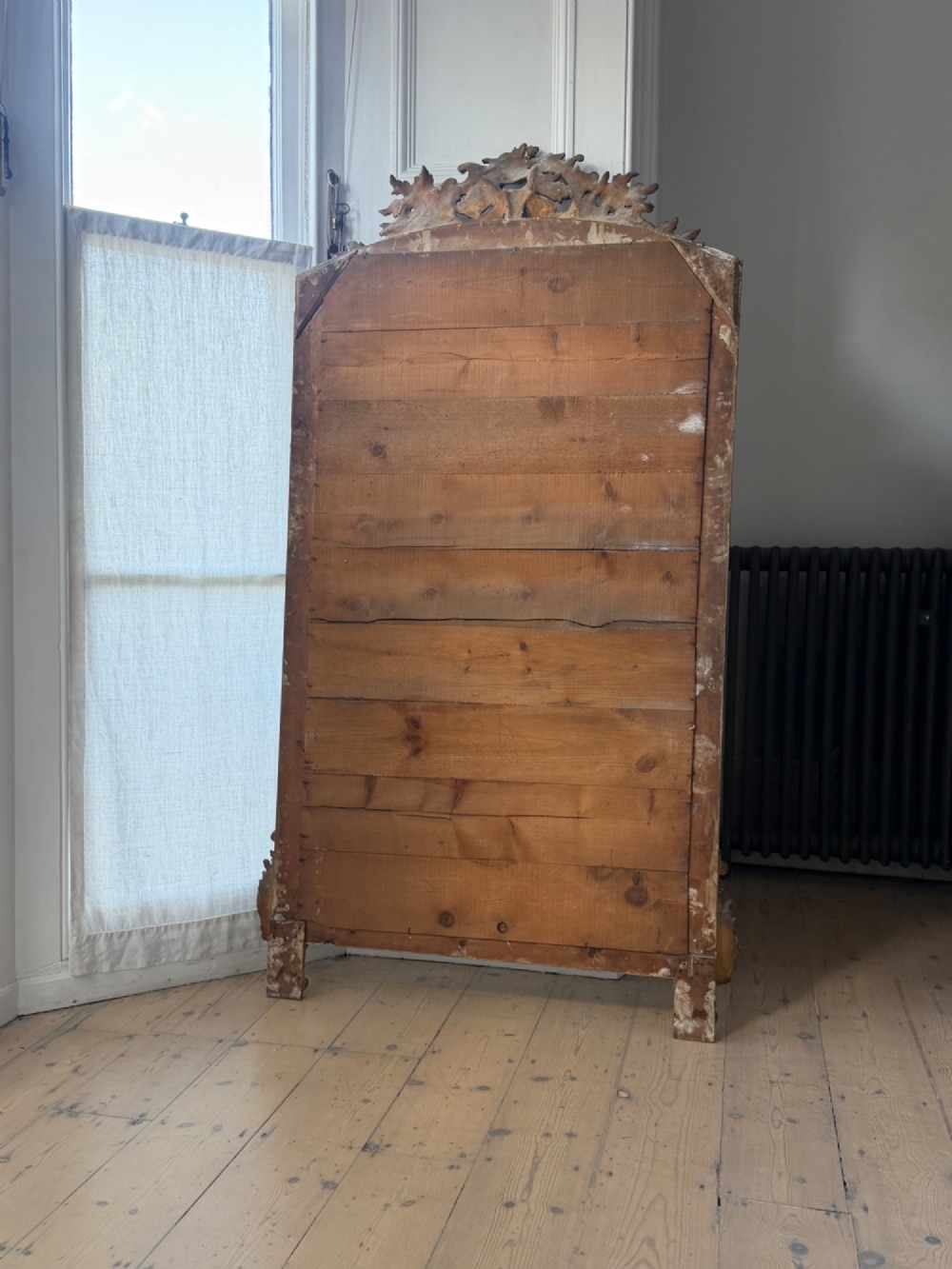 A large French gilded wood frame mirror featuring an arched top, a carved scroll cresting, and bevelled edge glass. View IX