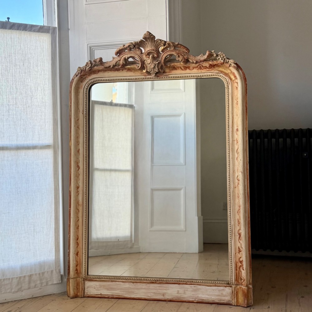 An antique French mirror featuring an arched top frame with a carved cresting and distressed off-white gesso finish. View XI