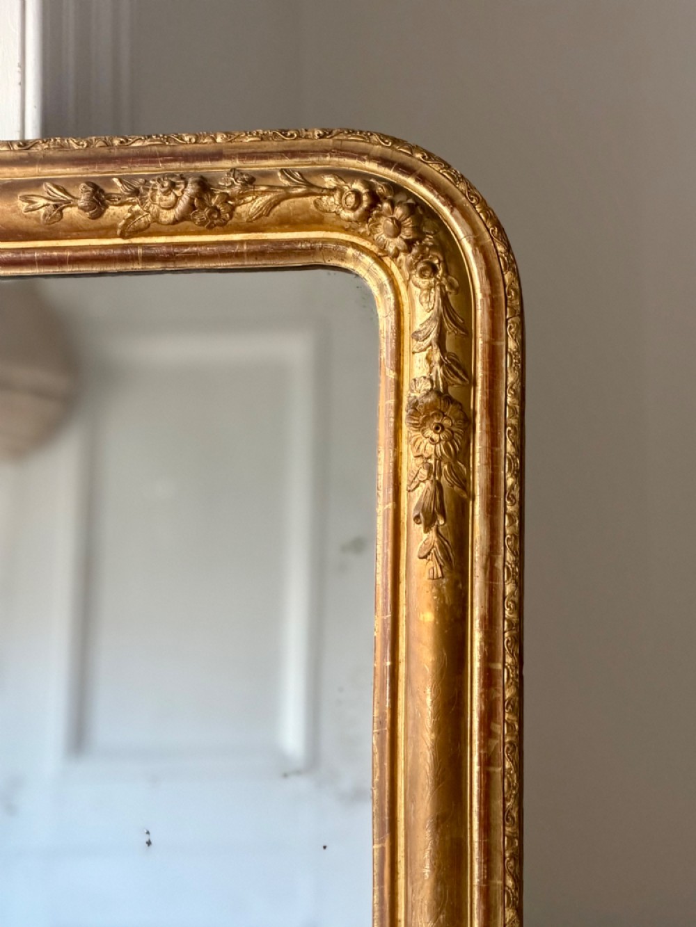 A large 19th-century French Louis Philippe mirror featuring a gilded wood frame with rounded top corners and foxed mercury glass. View III